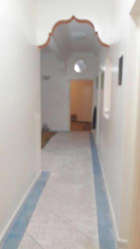 un pasillo vacío con una línea azul en una habitación en appartement kalaat mgouna, en Irmina