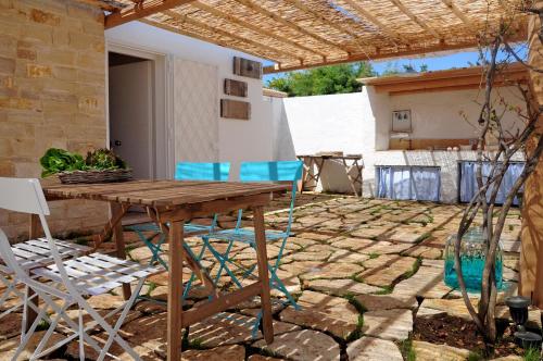 eine Terrasse mit einem Holztisch und Stühlen in der Unterkunft I Trulli Sul Mare in Trani