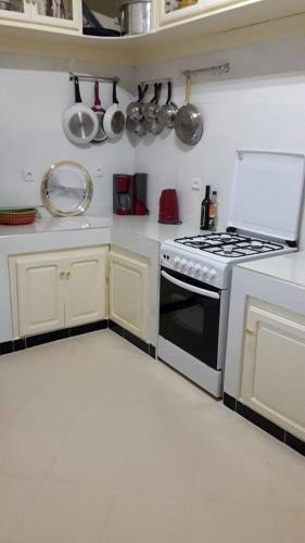 eine Küche mit einem Herd und weißen Schränken in der Unterkunft appartement kalaat mgouna in Irmina
