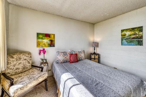 a bedroom with a bed and a chair at Maunaloa Shores 612 in Hilo