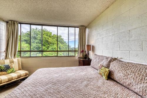 een slaapkamer met een bed en een groot raam bij Maunaloa Shores 612 in Hilo