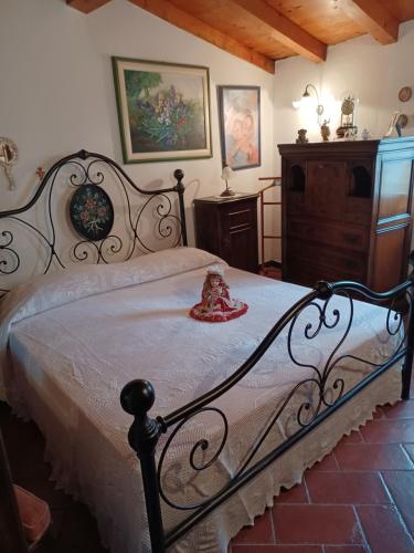 a bedroom with a bed with a doll sitting on it at Il Fontolo in Ponzano Superiore