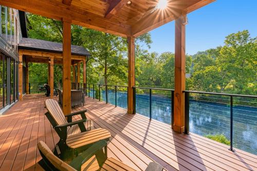a screened porch with two chairs and a view of the water at Enchanting Riverscape in Townsend