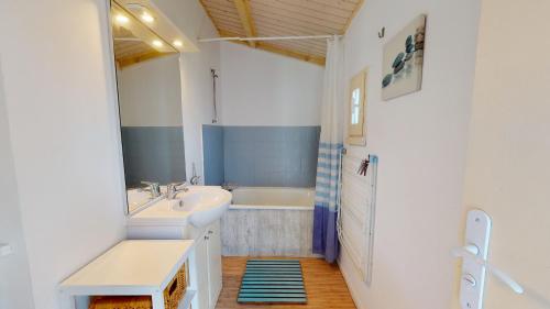 une salle de bain avec un lavabo et une baignoire dans l'établissement Le Cocon en Bord de Mer, à Bretignolles-sur-Mer