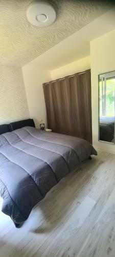 a bedroom with a large bed with a wooden headboard at Maison piscine in Saint-Amarin