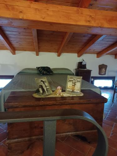 a bed with two pictures on a wooden table at Il Fontolo in Ponzano Superiore