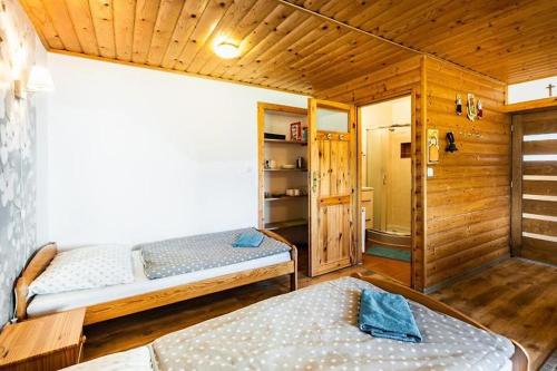 1 dormitorio con 2 camas en una cabaña de madera en uKozaków en Zubrzyca Dolna