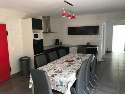 une cuisine avec une table, des chaises et un tissu de table dans l'établissement Maison plain pied 130m2, à Conca