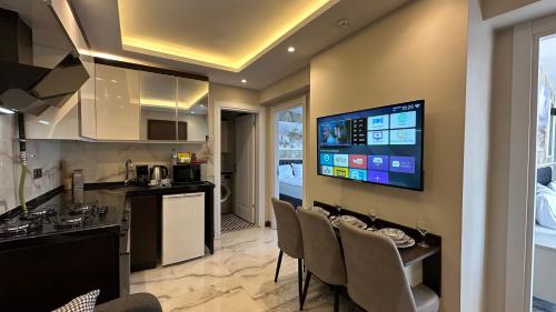 イスタンブールにあるMar Boutique Apartmentのバー付きのキッチン、壁掛けテレビが備わります。