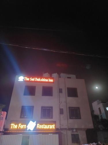 a building with a sign that reads the self displacement inn at Hotel Sai Dakshina Inn in Shirdi