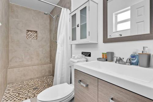 a bathroom with a toilet and a sink and a shower at Cheerful 4 Bedrooms house with Pool and Game Room in Hollywood