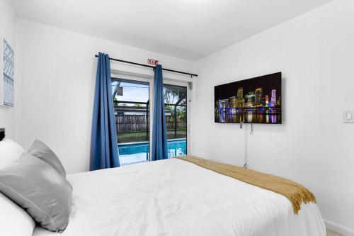 a bedroom with a white bed and a window at Cheerful 4 Bedrooms house with Pool and Game Room in Hollywood