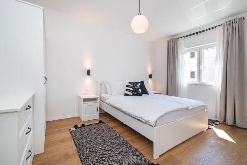 - une chambre blanche avec un lit blanc et une fenêtre dans l'établissement Apartment MAVI, à Zadar