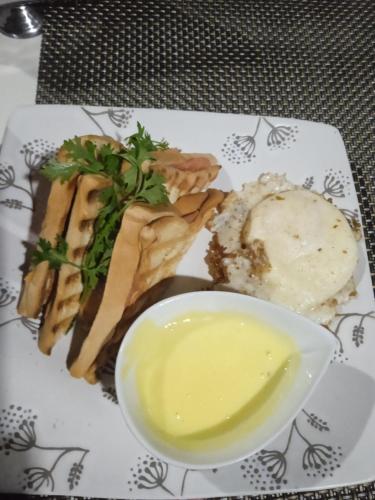a plate of food with a bowl of yellow sauce at Amazon Lodge Varillal in Iquitos