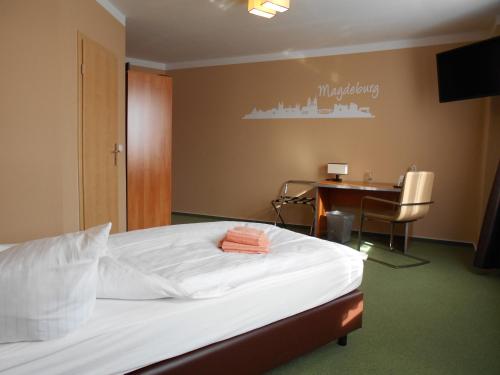 a bedroom with a bed and a desk and a table at Síu Hotel Magdeburg in Magdeburg