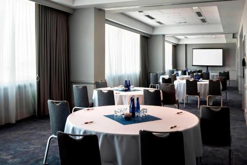 a conference room with tables and chairs and a screen at Philadelphia Airport Marriott in Philadelphia