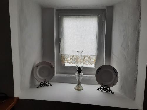 una ventana con un jarrón en un alféizar blanco en Grandma villa, en Pataias