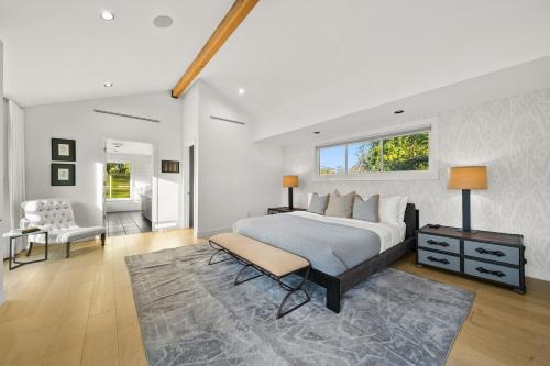 a bedroom with a bed and a chair and a window at Prestige Studio City Estate in Los Angeles