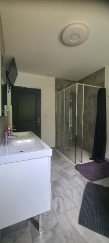 a bathroom with a shower and a white tub at Maison piscine in Saint-Amarin