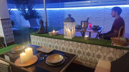 布拉內斯的住宿－Casa junto al mar，坐在餐桌上吃蜡烛的人