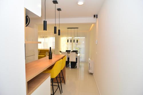 a kitchen with a counter and yellow stools at Apartment Bruno - Luxury Penthouse with Jacuzzi in Zadar