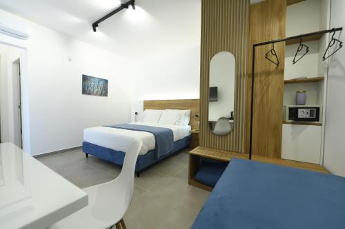 - une chambre avec un lit et une chaise dans l'établissement Blu in Blu Comfort rooms, à Terrasini