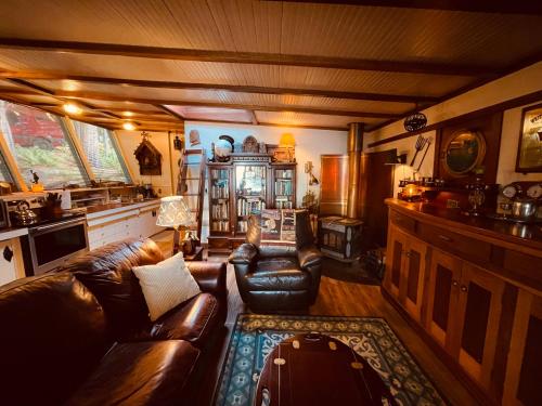 a living room with a leather couch and a kitchen at Sanctuary Seaside in Eastsound