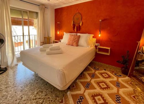 une chambre avec un grand lit avec un mur rouge dans l'établissement Mountain Retreat with stunning terrace views, à Pedralba