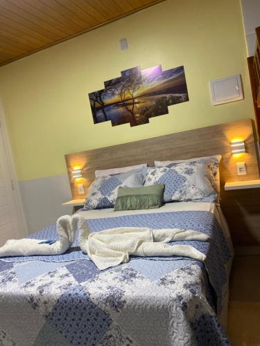 um quarto com uma cama com um cobertor em Chalé Temporada Porto dos Lençóis - Lençóis Maranhenses em Barreirinhas