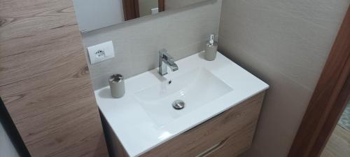 lavabo blanco en el baño con espejo en MIRTO di Sardegna, en Assemini