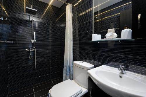 a bathroom with a toilet and a sink and a shower at Pervolia House Private Villa Near Airport in Kremasti
