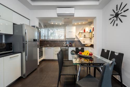 a kitchen with a table and chairs and a refrigerator at Pervolia House Private Villa Near Airport in Kremasti