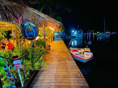 a dock with a boat on the water at night at Mar Marine Yacht Club in Rio Dulce