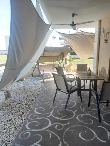 a patio with a table and chairs and umbrellas at Danai Exclusive . Ξεχωριστές ομορφες διακοπές in Flogita