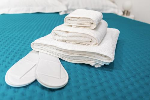 a pile of towels and shoes on a bed at MELO 48 in Bari