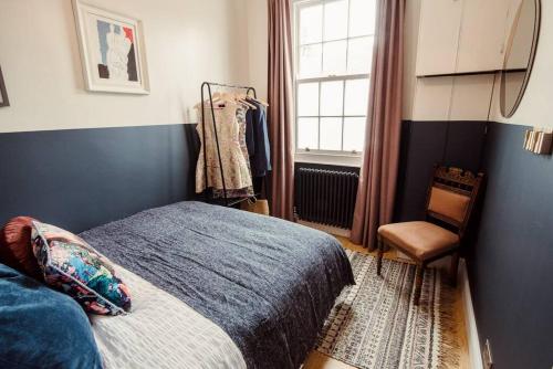 a bedroom with a bed and a window and a chair at Artistic hideaway within York’s ancient city walls in York