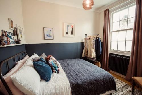 a bedroom with a bed with pillows on it at Artistic hideaway within York’s ancient city walls in York