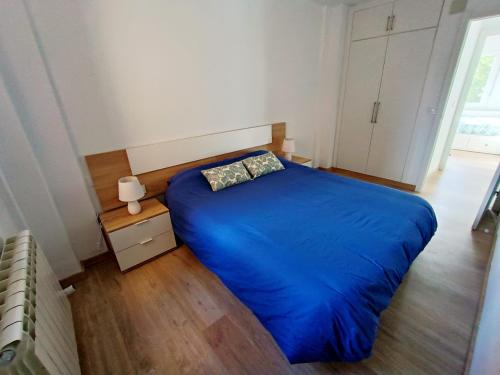 una camera con letto blu e pavimento in legno di La Casita de Requejo a Zamora