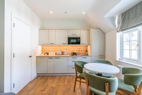 a kitchen with white cabinets and a table and chairs at The Queen Stage in Effingham