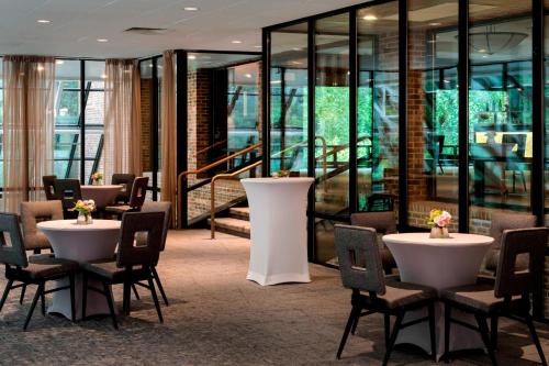 a restaurant with tables and chairs and glass walls at Princeton Marriott at Forrestal in Princeton
