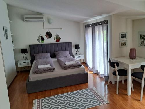 a bedroom with a bed and a table and a desk at Apartments Thea in Mostar