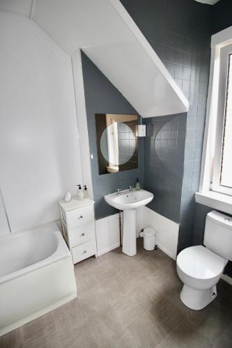 a white bathroom with a sink and a toilet at Hunters Guest House in Brodick