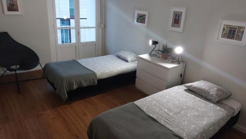 a bedroom with two beds and a dresser and a window at Memoria 49 in Lisbon