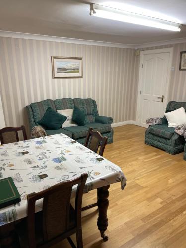a living room with a table and a couch at Large Townhouse with Gardens in Kingscourt