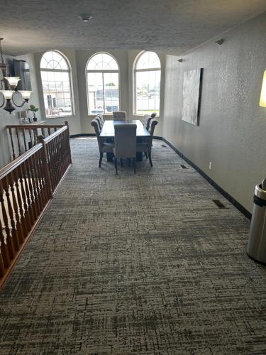 a dining room with a table and chairs and windows at Platte Valley Inn in Columbus