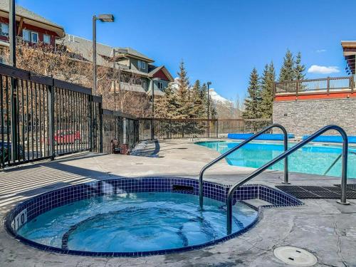 a hot tub in a patio next to a building at Beautiful Renovated Wolf 2Bed 2Bath in Canmore