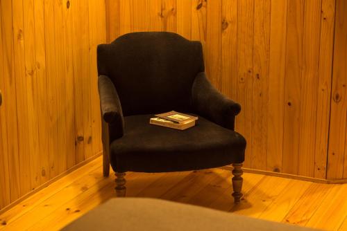 a black chair with a book on top of it at Hotel Faro Azul Valparaíso Cerro Alegre in Valparaíso