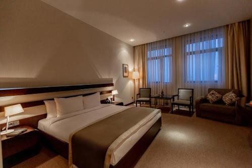 a hotel room with a large bed and a chair at Zirve Hotel in Shahdag