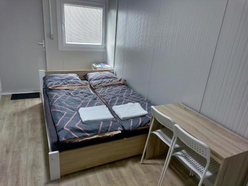 a small bedroom with a bed and a table at Domino in Hluboká nad Vltavou