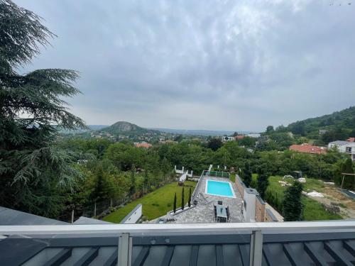 a view from the balcony of a house with a swimming pool at Luxurious Panorama House with Pool and Sauna in Budaörs